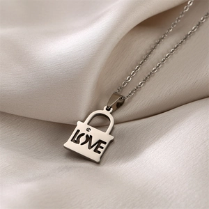 Macro shot of silver padlock pendant with LOVE cutout and rhinestone on silk