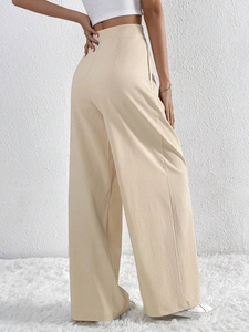 Elegant beige high-waisted wide-leg trousers with textured fabric and a fluid drape