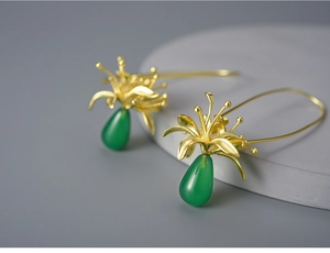 Macro shot of S925 silver spider lily earrings with green chalcedony drops and gold finish