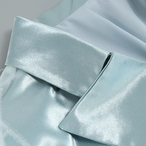 Gros plan sur le tissu en satin bleu clair avec bordure en plumes blanches