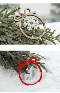 Close-up of laser-cut wooden Christmas ornaments with snowflake and elk motifs