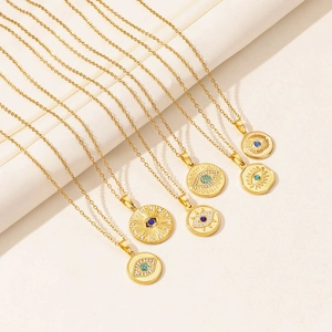 Detailed view of gold evil eye necklaces with blue stones on a soft fabric background