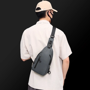 Back view of a grey minimalist crossbody chest bag worn over a beige shirt
