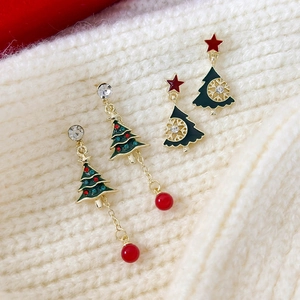 Festliche Weihnachtsbaum-Ohrringe mit roten Perlen und Sternen auf Strickhintergrund