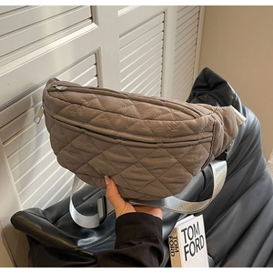 Detail of taupe quilted nylon crossbody bag featuring silver zipper and adjustable strap