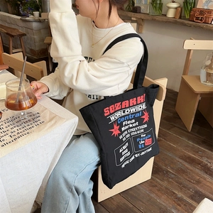 Detail of a large canvas tote bag featuring vintage American typography in a cafe setting