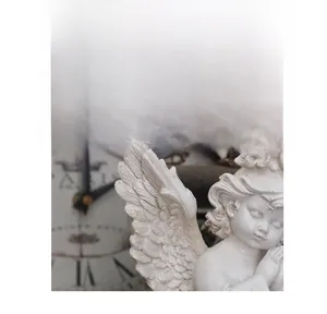 Detailed close-up of white resin cherub angel sculpture showing intricate wing feathers