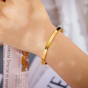 Macro shot of 18k gold plated C-shape bracelet featuring Forever Love and Only You engraving