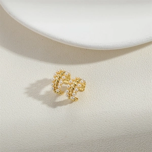 Elegant gold-tone C-shaped hoop earrings with embedded white pearls on neutral background