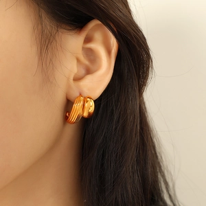 Elegant C-shaped heart earrings in gold-plated stainless steel worn by a model