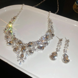 Sparkling water drop rhinestone necklace and earrings set on white display tray
