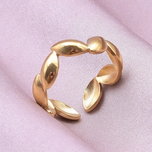 Detail of adjustable gold geometric link ring on elegant pink silk background