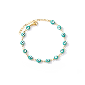 Detail of bohemian gold-linked bracelet featuring turquoise blue evil eye enamel beads