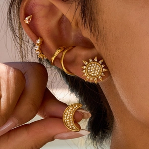 Golden sun and moon stainless steel stud earrings with rhinestones on model ear