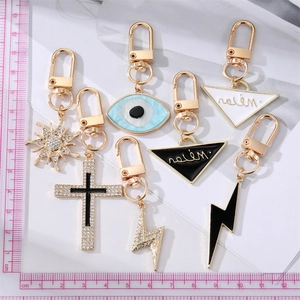 Set of gold alloy keychains featuring evil eye, sun, and lightning charms with measurements