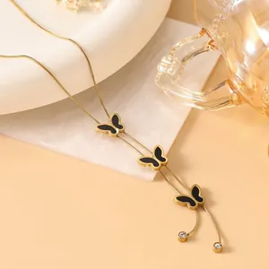 Detail of 18K gold plated clover necklace with black butterfly charms and white zircons