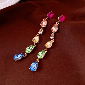 Détail de pampilles gouttes d'eau en strass colorés sur boucles d'oreilles dorées