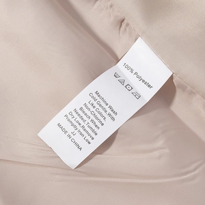 Détail de l'étiquette d'entretien sur une veste indiquant 100% polyester et entretien
