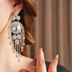 Dettaglio orecchino vintage argento con nappe di strass brillanti indossato da modella