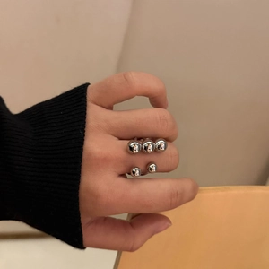 Polished silver sphere ring set worn on hand featuring double and triple bead design