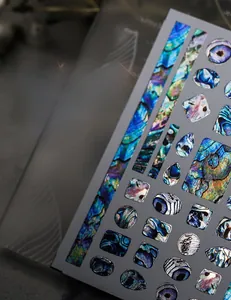 Dettaglio di adesivi per nail art con motivi metallici iridescenti in conchiglia