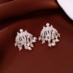 Detail of silver fan-shaped tassel earrings with pearls and crystals on velvet