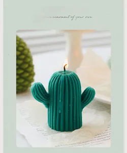 Vue détaillée d'une bougie parfumée en forme de cactus vert allumée sur papier vintage