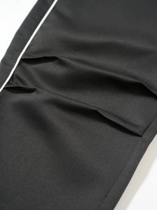 Detail of high-density black twill fabric with white side stripes and fine texture