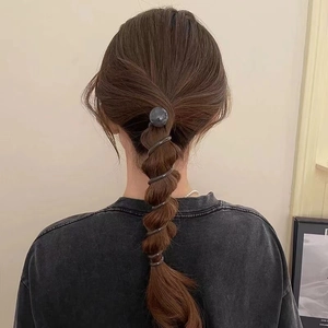 Deep grey spiral bubble hair tie with decorative bead shown on a ponytail hairstyle