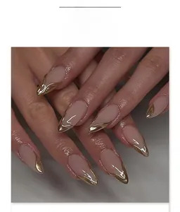 Detail of short almond press-on nails with 3D gold foil borders and nude pink base color