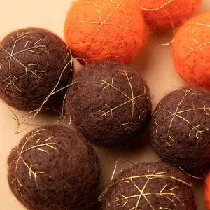Plush wool felt Christmas balls in orange and brown with golden snowflake embroidery