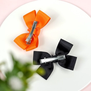 Halloween girls hair clips set with orange and black grosgrain ribbon bows on a white plate