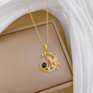 Macro detail of gold Pegasus moon necklace with white crystals and black projection bead
