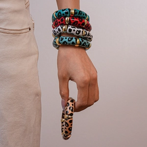 Detail of colorful acrylic leopard print bangles set with gold metallic spacer beads