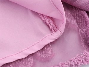 Close-up of the mauve textured fabric with jacquard mesh layers and fine stitching