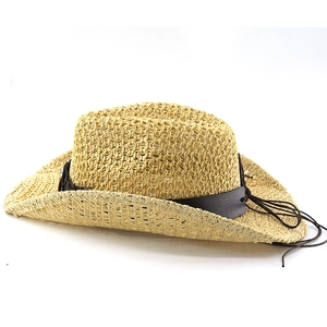 Detailed close-up of woven straw cowboy hat showing hollow crochet patterns and leather band