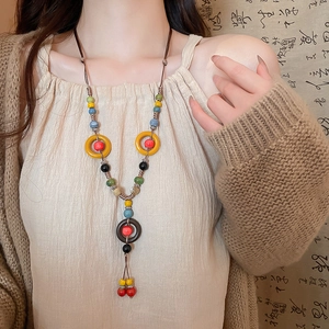 Close-up of bohemian ceramic beaded necklace with large rings and hand-woven wax cord