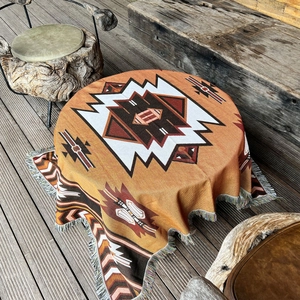 Detailed close-up of bohemian woven blanket with geometric patterns and colorful tassels