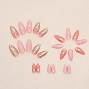 Almond shape press-on nails with pink glitter gradient and horizontal gold line accents