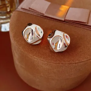 Elegant silver irregular pleated earrings displayed on a luxury brown velvet jewelry box