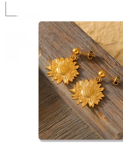 Detailed close-up of golden sunflower earring on a textured wood surface with soft light
