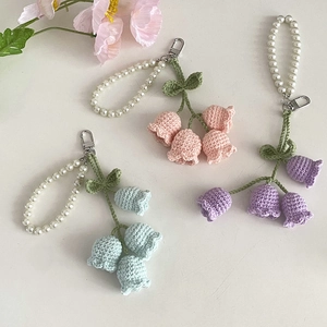 Close-up of handmade crochet lily of the valley flowers in pink, purple and blue