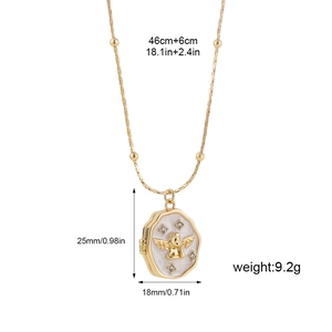 Detailed view of golden locket pendant with angel relief and faux pearl inlay shell