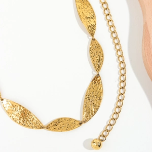 Detail of a golden hammered metal leaf waist chain with spherical pendant decoration