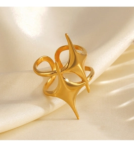 Macro detail of 18K gold plated stainless steel star ring on smooth cream satin fabric