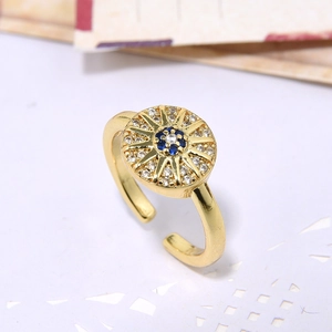 Adjustable gold ring featuring a geometric sunburst design with blue zircon center