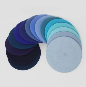 Detail showing various blue wool berets in gradient shades from light blue to navy