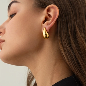 Polished 18K gold plated chunky teardrop earrings worn by model for a modern fashion look