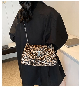 Detail of leopard print handbag featuring a silver T-buckle and chic metal chain strap