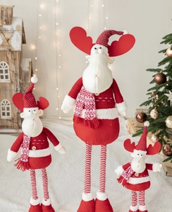 Three plush Christmas reindeer dolls in red and white stripes with festive decor